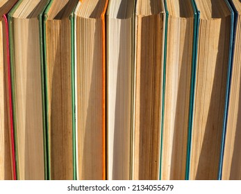 Old, battered and faded hardcover books or textbooks in a bookstore or library. A stack of hardcover Books. The concept of 