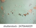 An old battered wall.Peeling plaster on the wall in the house.Old whitewash on the wall.Abandoned building background.