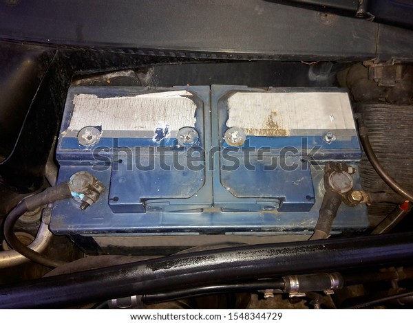 Old\
battery, plugged in and embedded in the car,\
image