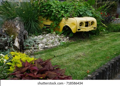 Old Beat Up And Recycled Use Of A French Car In The Garden With Flowers