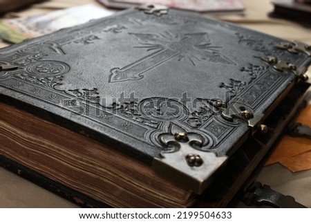 old bible book cover, black leather engraved with religious cross symbol, historic gothic look