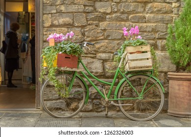 An old bicycle decorated with flowers outside a shop in Florence, Italy.