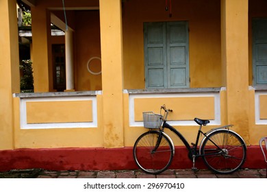 Old bicycle parked in front of a rustic cottage
