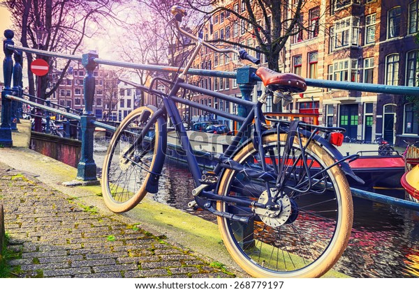 Altes Fahrrad neben dem Kanal stehend. Stadtbild von Amsterdam