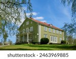Old Big beautiful green wooden house with balcony and terrace. Well cut lawn. Tile roof.                          