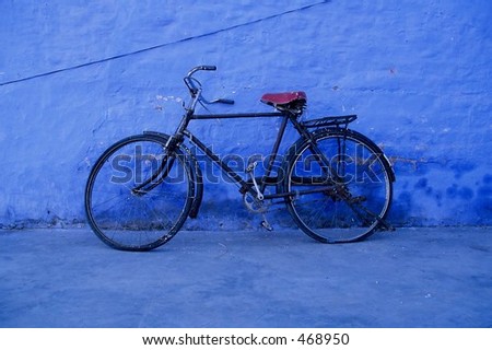 Old bike next to a blue wall