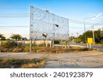 An old billboard, empty panels, in the road