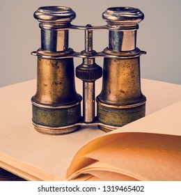 Old binoculars and an open notebook. Web banner.