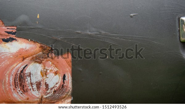 Old black car
door, a paint fade and
crack