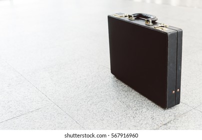 An Old Black Leather Briefcase On The Floor