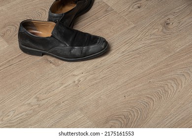 Old Black Leather Male Shoes On An Untidy Hardwood Floor