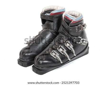 Old black leather ski boots isolated on white.