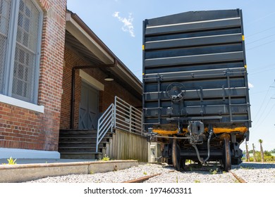 Old Black Metal Train Boxcar At An Abandoned Brick Station