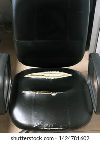 Old Black Office Chair. Vintage Leather Chair With Sponges Out. Old And Damaged Furniture.