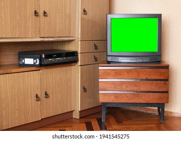 An Old Black TV With A Green Screen To Add Video And A VCR Against Old Furniture From The 1980s And 1990s.Design In The House In The Style Of The 1980s And 1990s.