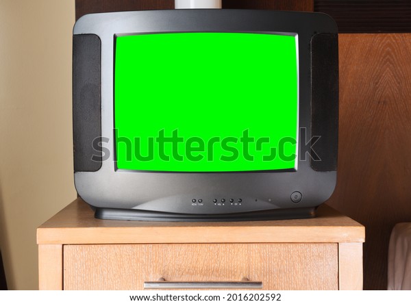 An old black TV with a green screen for
adding video and images is on the bedside table in the apartment .
Vintage TVs from the 1980s 1990s 2000s.
