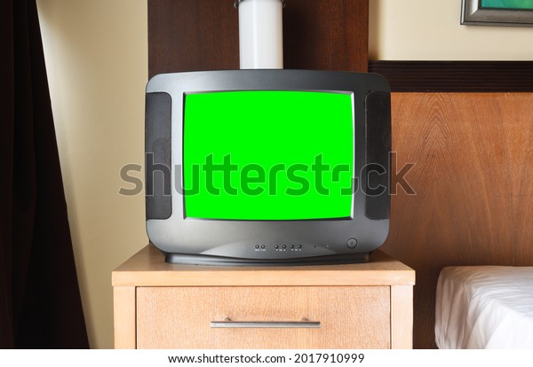 An old black TV with a green screen for\
adding video and images is on the bedside table in the apartment .\
Vintage TVs from the 1980s 1990s 2000s.\
