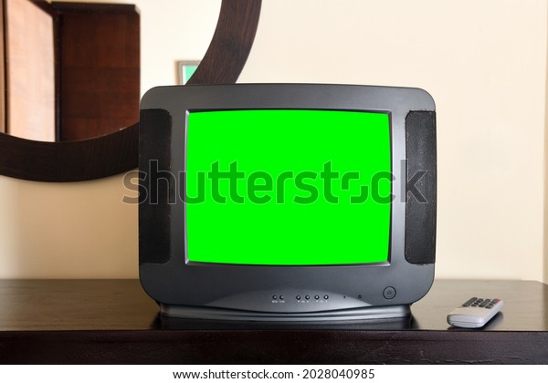 An old black TV with a green screen for
adding video and images is on the bedside table in the apartment .
Vintage TVs from the 1980s 1990s 2000s.
