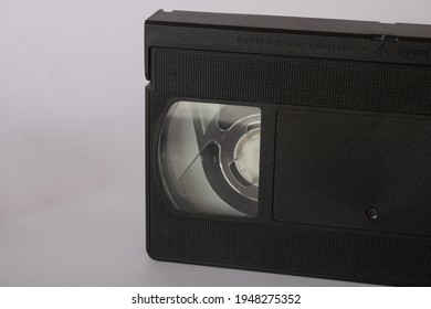 Old Black VHS Video Tape, Cassette On A White Background, Overhead Flat Lay. VHS Tapes Used For Reproduction Of Movies And Footage Peaked In The 90's. Copy Space For Text, Retro Concept