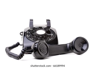 An Old Black Vintage Rotary Style Telephone Off The Hook Isolated Over A White Background.