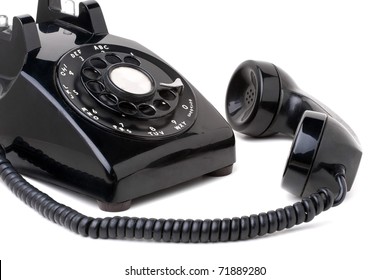 An Old Black Vintage Rotary Style Telephone Off The Hook Isolated Over A White Background.