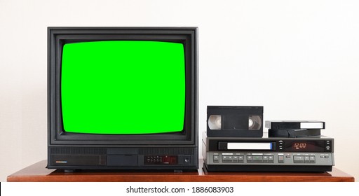 Old Black Vintage TV With Green Screen To Add New Images To The Screen, VCR On Wallpaper Background From The 1980s, 1990s, 2000s.