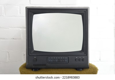 Old Black Vintage TV Set Against A Brick Wall From The 1980s, 1990s, 2000s.