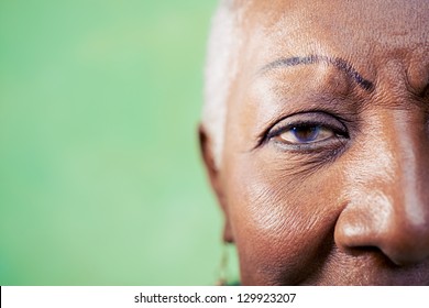 Old Black Woman Portrait, Close-up Of Eye And Face On Green Background. Copy Space