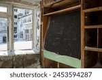 An old blackboard in a classroom at an abandoned school in the Arctic. Snow outside the broken window. Devastation in the Far North of Russia. Problems with the education system in the Russian regions