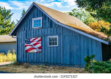 Old Blue Barn With Painted United States Flag Of Red, White And Blue In Rural America.