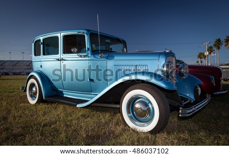 Old blue car with whitewall tires on the grass of Classic Cars Exhibition in Florida, USA.