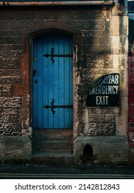 Old Blue Church Door In Gloucester UK With Bent Keep Clear Emergency Exit Sign