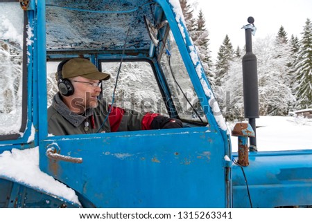 old blue fordson dexta tractor plowing snow