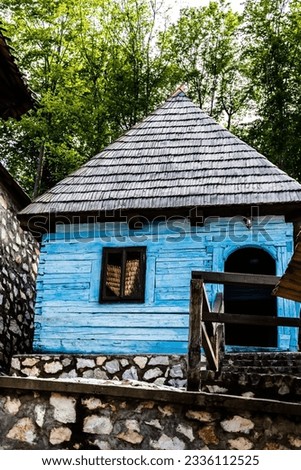 Old blue house in traditional Romanian style exposed in the courtyard of the Izbuc monastery. Bihor, Romania.