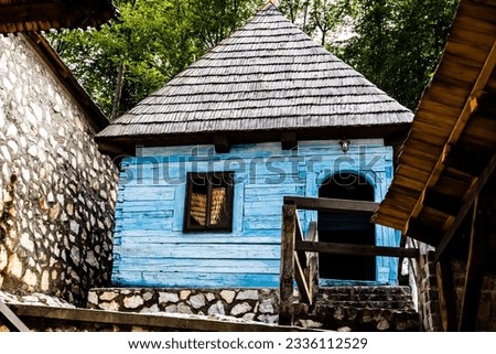 Old blue house in traditional Romanian style exposed in the courtyard of the Izbuc monastery. Bihor, Romania.