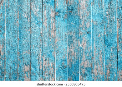 Old blue wooden background. Peeling blue paint.Badly cracked blue paint on wooden planks.