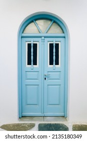 Old blue wooden door against clear white wall in Greece - Shutterstock ID 2135180349