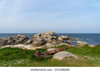 Old Boat Anchor In Front Of A Rocky Outcrop
 