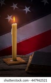 Old Book And Burning Candle. Flag Of America By Candlelight. Walk Through Pages Of Past. Respect The Country's History.