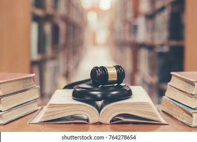 Old book in library with judge gavel on open law textbook in court archive text collection study room for copyrights day and international legal rights concept