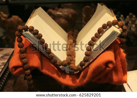 An old book on a red cloth with Rudraksha beads. Stock photo © 