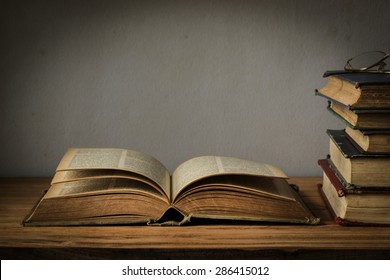 Old Book Open On A Wooden Table With Glasses