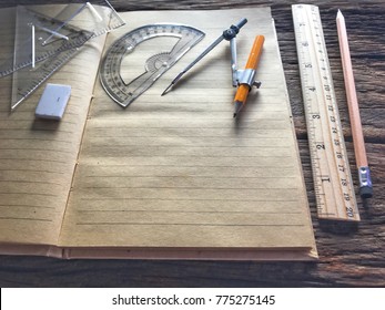 Old book, pencil, ruler, eraser and drawing equipment on wooden table and the space for letters or symbols with the memo concept, time, past, ancient, handmade, vintage, learning, diary