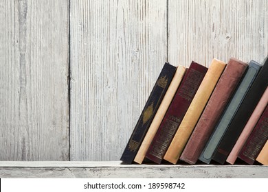 old book shelf blank spines, empty binding stack on wood texture background, knowledge concept