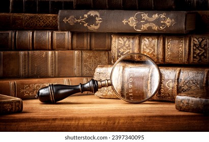 Old books and antique magnifying glass on a wooden background. An ancient book and magnifying glass as a symbol of history, education. Old book history background. - Powered by Shutterstock