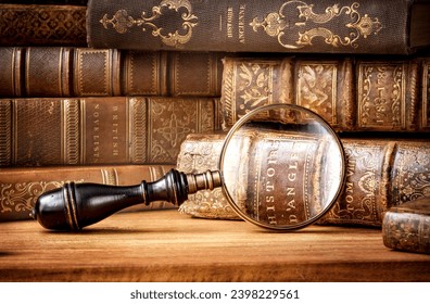 Old books and antique magnifying glass on a wooden background. An ancient book and magnifying glass as a symbol of history, education. Translation of book titles - history of England, ancient history. - Powered by Shutterstock