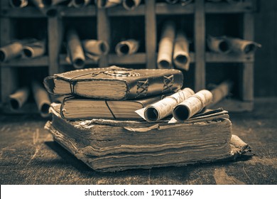 Old books and antique scrolls in library on wooden table