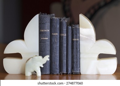 Old Books (bibles And Prayer Books) Between Onyx Bookends With An Elephant.