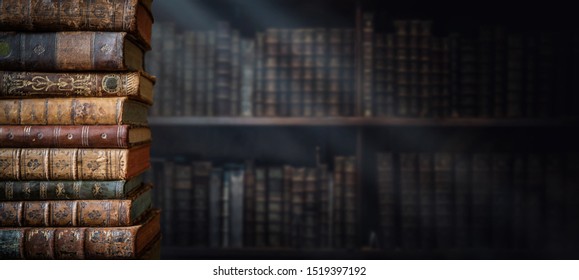 Old books on wooden shelf and ray of light. Bookshelf history theme grunge background. Concept on the theme of history, nostalgia, old age. Retro style.