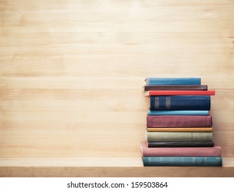 Old books on a wooden shelf. 